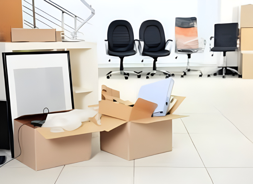A workspace filled with office furniture and cardboard boxes, highlighting the activity of commercial movers.