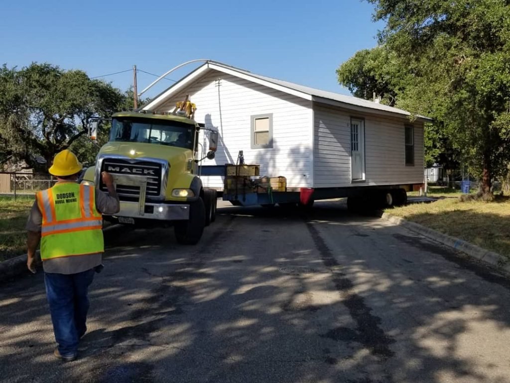 A man loads a house onto a truck for Full House Moving, demonstrating the moving process.